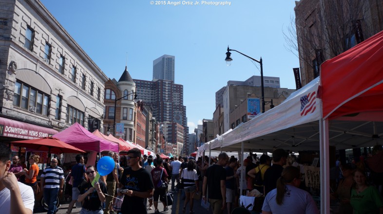 The clear blue sky and the structures of downtown Jersey City overlooks the wonderful crowd of the street fair  © 2015 Angel Ortiz Jr. Photography